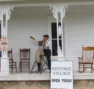Storyteller on porch at Historic Village, Mackinaw City