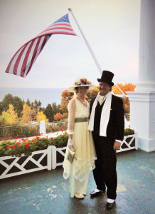 Lisa and Nate on the porch of the Grand Hotel with the Straits of Mackinac in the background