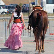 Shawn wearing corset and pink bustle skirt; walking with horse