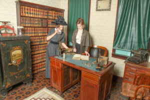 models in Edwardian clothing making a call from the lawyer's desk