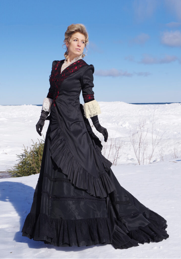 woman-wearing-black-Victorian-gown-with snowy-background